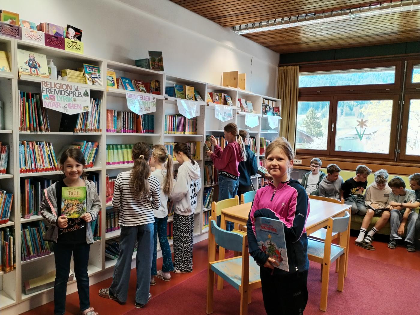 Kinder in der Bibliothek mit Büchern