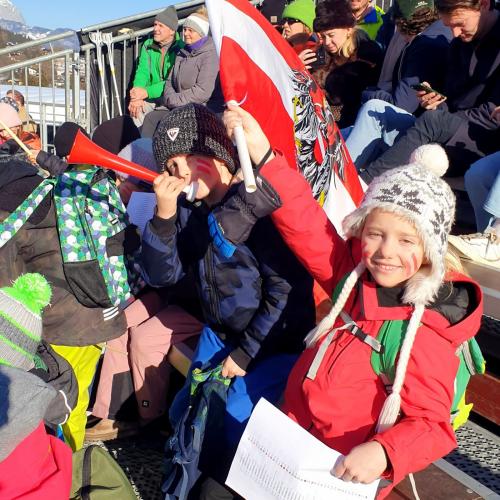 Kinder mit Fahnen und Tröten auf der Tribüne