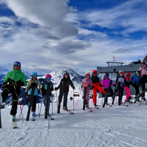 Skigruppe mit Skilehrer bei Bergstation