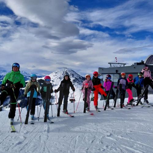 Skigruppe mit Skilehrer bei Bergstation