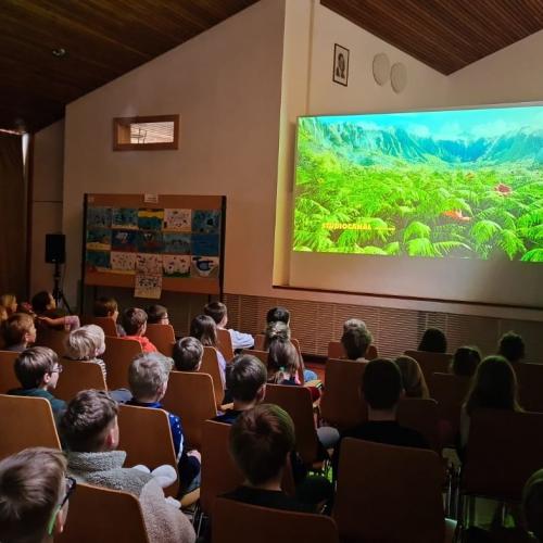 Schulfilm in der Aula, die Kinder sitzen vor der Leinwand