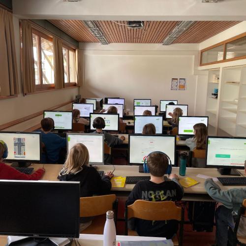 Kinder vor den Computern von hinten