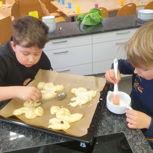 2 Kinder bepinseln den Teig 