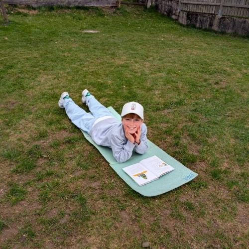 Mädchen liegt im Gras beim Lesen
