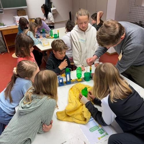 Kinder sitzen beim Workshop um Tisch
