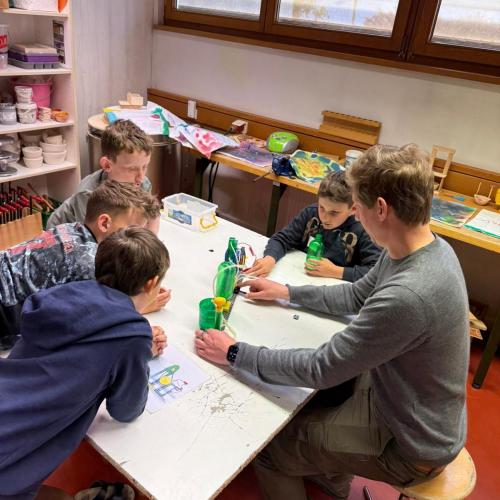 Kinder sitzen beim Workshop um Tisch