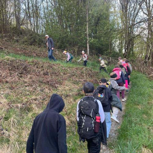 Kinder wandern im Gänsemarsch einen schmalen Weg hinauf