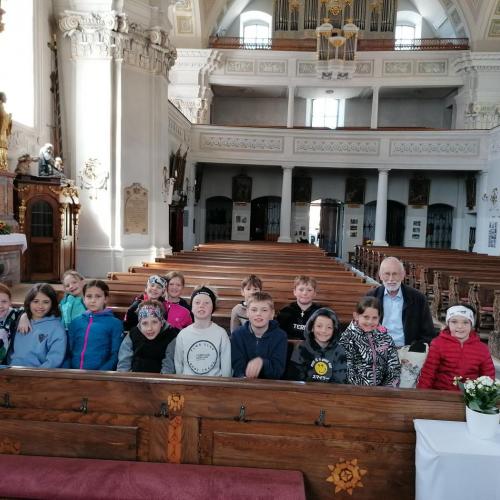 Kinder mit Sepp Wurzrainer in den Bänken der Kirche