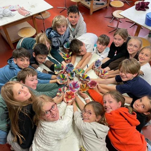 Kinder im Kreis mit gefilzten Blumen in der Hand
