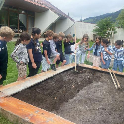 Kinder um das Beet herum