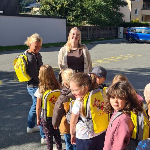 Kinder stellen sich mit Rucksäcken an