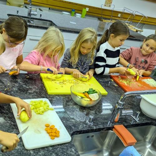 Kinder beim Schneiden des Gemüses für die Bohnensuppe
