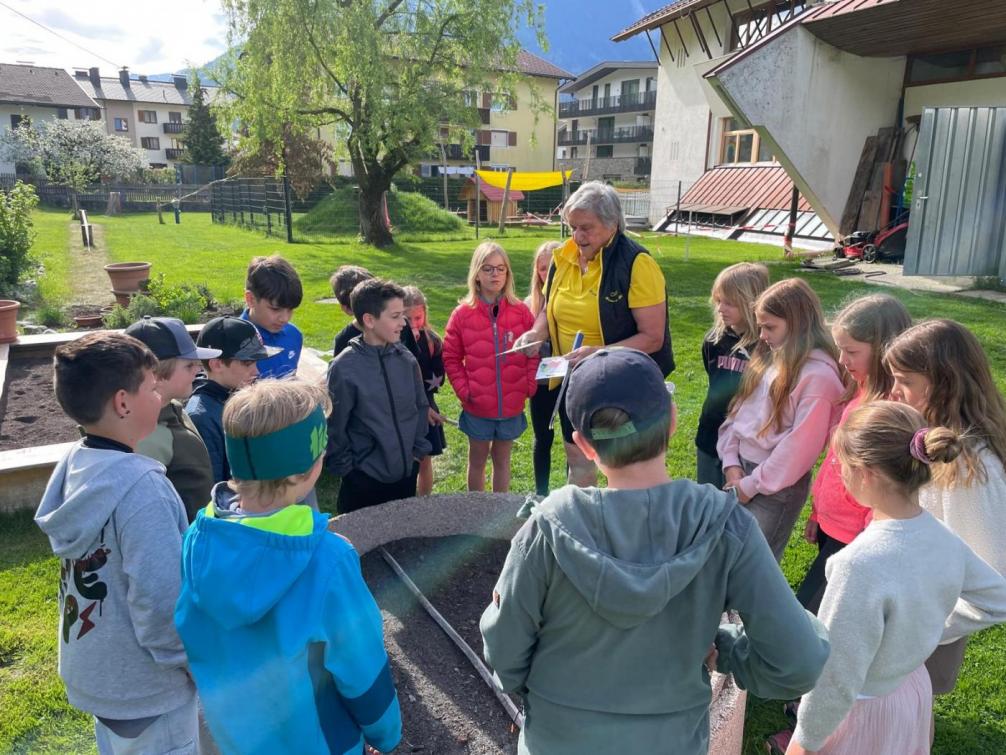 Gruppe von Kindern und Traudi vor Hochbeet