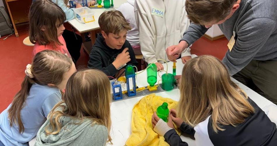Kinder sitzen beim Workshop um Tisch