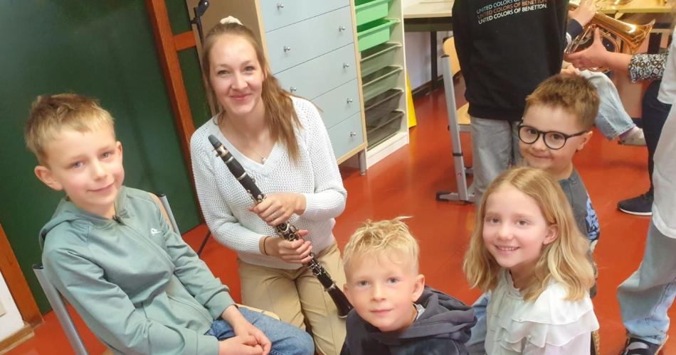 Gruppe von Kindern um Frau mit Klarinette herum