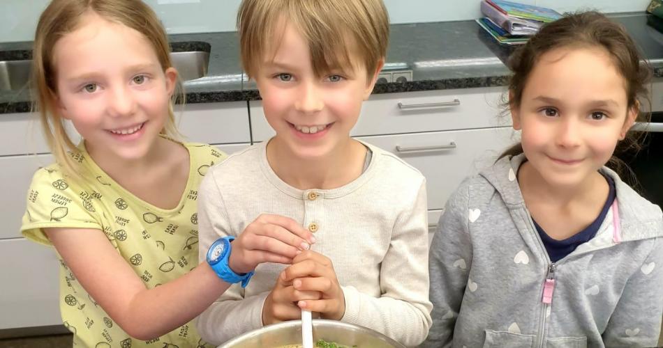 Kinder vor Gemüsesuppentopf