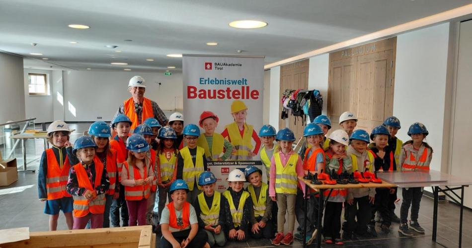 Schulklasse mit Warnwesten und Helmen
