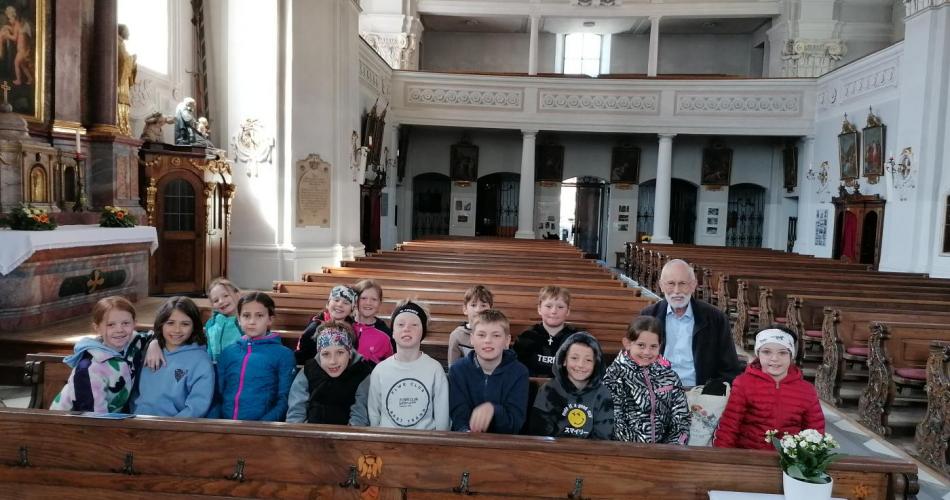 Kinder mit Sepp Wurzrainer in den Bänken der Kirche