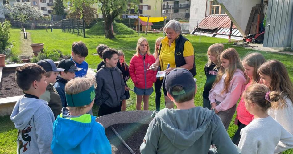 Gruppe von Kindern und Traudi vor Hochbeet