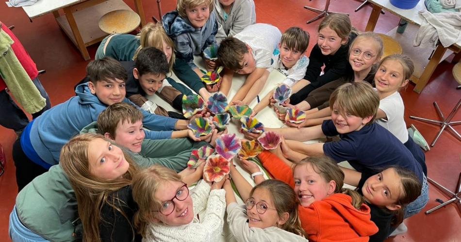 Kinder im Kreis mit gefilzten Blumen in der Hand